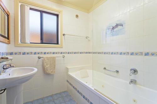 伊登舒适小湾别墅酒店的白色的浴室设有水槽、浴缸和水槽。