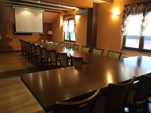 图兹拉Motel Royal的一间会议室,配有长桌子和椅子