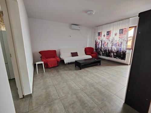BragadiruApartament spațios的客厅配有白色沙发和红色椅子