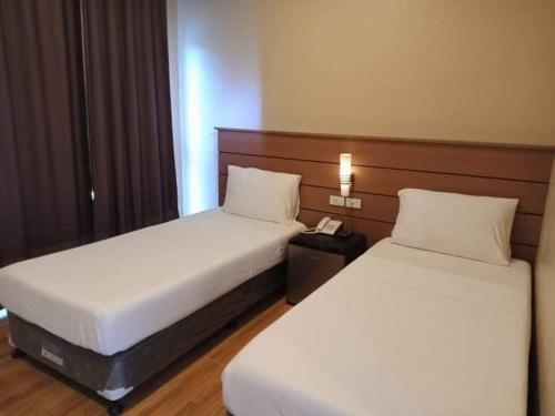 MagamomoSamal Sands and Shores的酒店客房设有两张床和电话