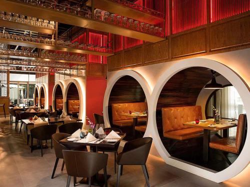 迪拜宜必思中央一号酒店 - 迪拜世界贸易中心的一间带桌椅和红色墙壁的餐厅