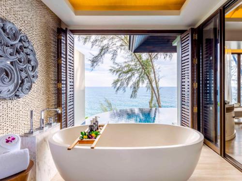 奈通海滩Pullman Phuket Arcadia Naithon Beach的带浴缸的浴室,享有海景。