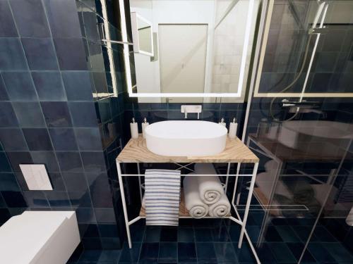 锡比乌Mercure Sibiu Arsenal的一间带水槽和镜子的浴室