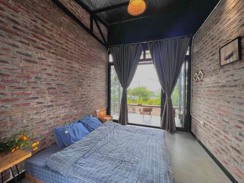 木州县Vườn Trên Mây - Skyline Farm & Homestay的卧室配有砖墙内的床铺