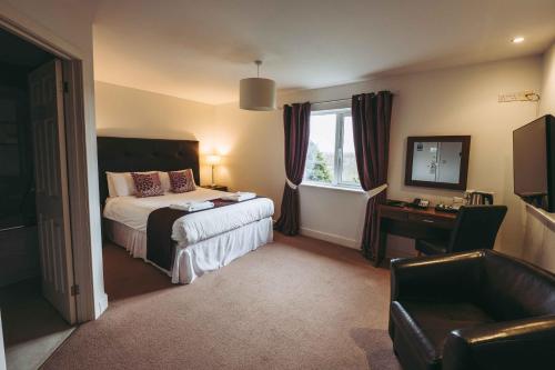 海布里奇The Grange Hotel Brent Knoll的酒店客房设有床和窗户。