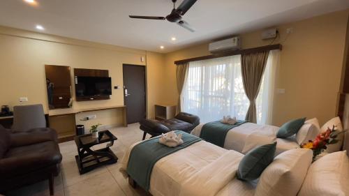 班加罗尔Hotel Banyan Tree Yeshwanthpur的一间酒店客房,设有两张床和电视