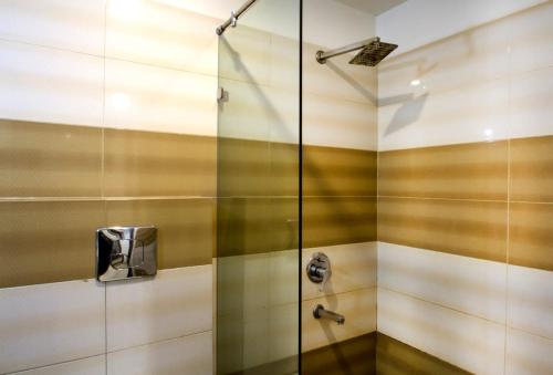 商沙巴Rainbow International Hotel Airport Zone Shamshabad的浴室里设有玻璃门淋浴
