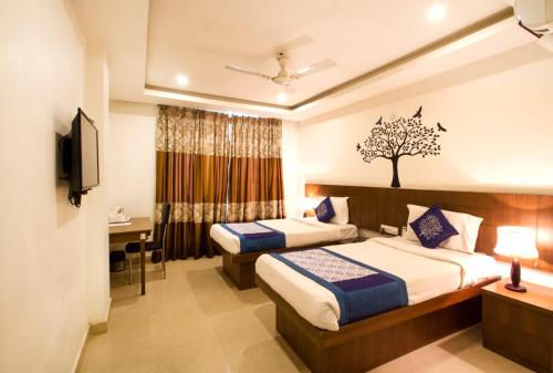 商沙巴Rainbow International Hotel Airport Zone Shamshabad的酒店客房设有两张床和电视。
