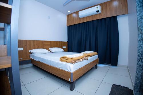 博尔本德尔24 CARAT STUDIO APARTMENTS的一间卧室配有一张蓝色窗帘的床