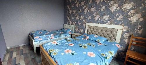 GodoganiGuest House Godogani的卧室设有两张单人床,装饰有花卉壁纸