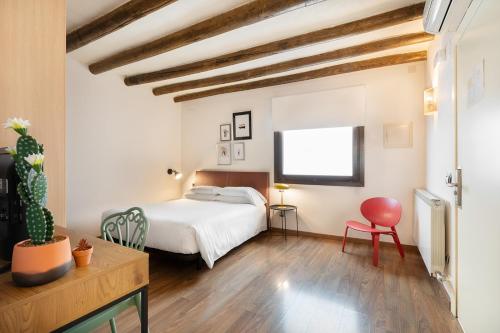图德拉Hostal Pichorradicas的卧室配有白色的床和红色椅子