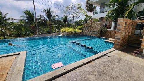 Ban Thung ThongPlus condominium 2 kathu的房屋前的游泳池