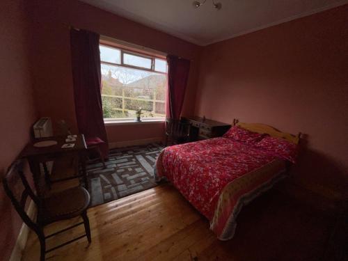 爱丁堡Lovely double room in very good area的一间卧室配有一张带红色棉被的床和窗户。