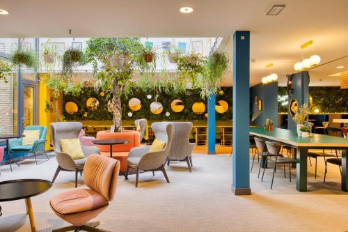 布鲁塞尔B&B HOTEL Brussels Centre Louise的一间设有桌椅和植物的等候室