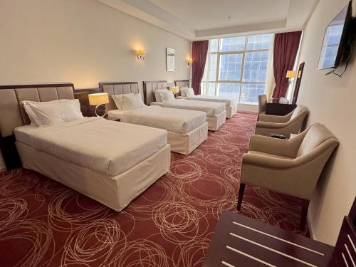 麦加Al Rayyan Towers 4的大型酒店客房,配有两张床和椅子