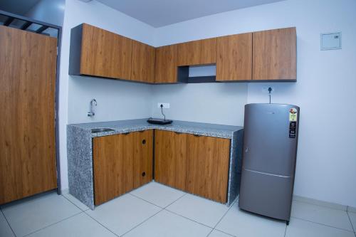 博尔本德尔24 CARAT STUDIO APARTMENTS的厨房配有冰箱和木制橱柜。