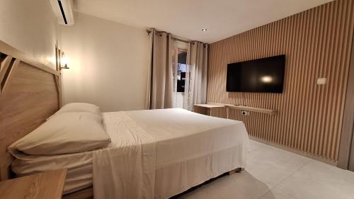 蒙舒瓦西Residence Capri的一间卧室配有一张床和一台平面电视