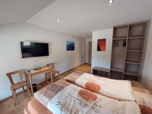 拉绍德封弗梅堡勒雷尔住宿加早餐旅馆的一间卧室配有一张床、一张桌子和一台电视。