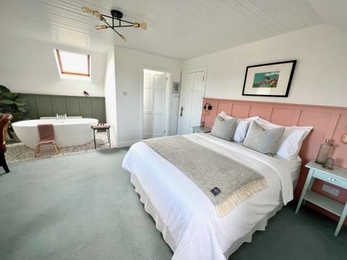 海上费萨德Thistledown Lodge的一间卧室设有一张大床和一个浴缸