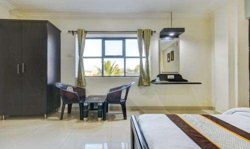 钦奈Hotel Saibala Inn的一间卧室配有桌椅和窗户。