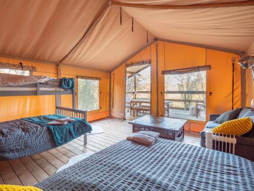 GartmoreCobleland Campsite的帐篷内的卧室,配有一张床和一张桌子