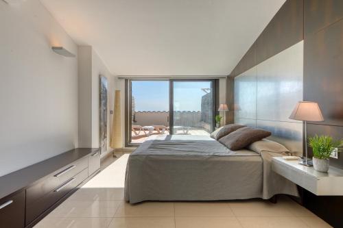 罗萨斯Mileni Atico Duplex Roses - Immo Barneda的一间卧室设有一张大床和一个大窗户