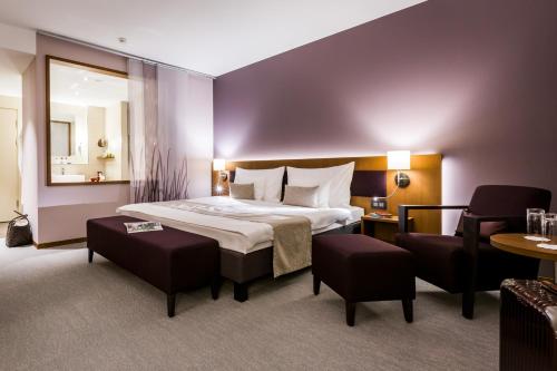 图恩Deltapark Vitalresort****的酒店客房带一张大床和一把椅子