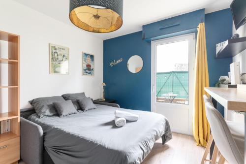 南特Studio Centre-Ville avec Terrasse et Parking Sécurisé Gratuit的一间卧室配有一张蓝色墙壁的床和一扇窗户