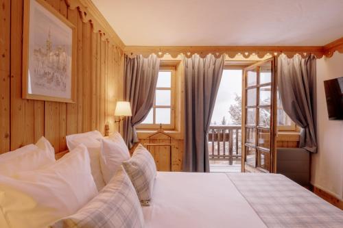 梅杰夫La Ferme du Golf的一间卧室设有一张大床和一个窗户。
