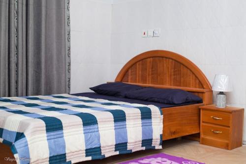 库马西Luxury Spacious Apartment的一间卧室配有一张带蓝白色毯子的床