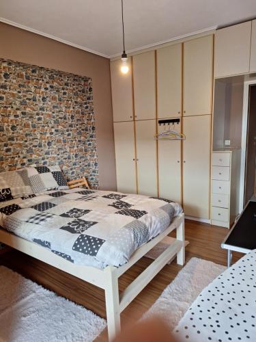 莱瓦贾Άρτεμις的一间卧室设有一张床和砖墙