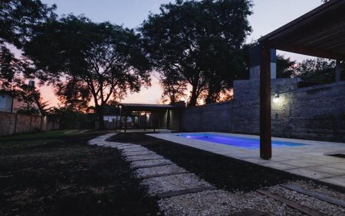 梅赛德斯LA CASA DE AL LADO的黄昏时带游泳池的后院