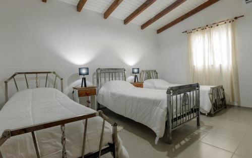 梅赛德斯LA CASA DE AL LADO的一间卧室设有两张床和窗户。