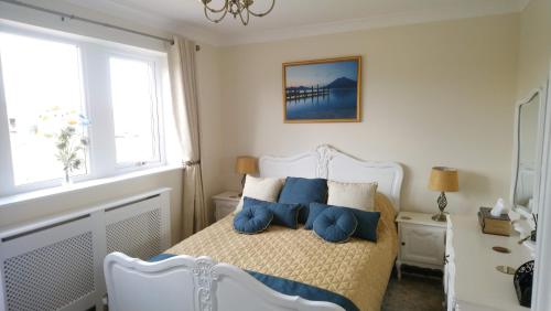 托德莫登Parkin House Guest House的一间卧室配有白色床和蓝色枕头