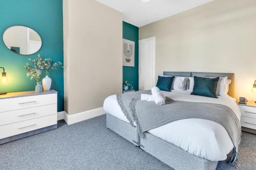 莱斯特Inspira Stays - Monthly DISCOUNTS - Stylish Modern 2 Bedroom House - Free Parking - Wi-Fi的一间卧室配有一张大床和镜子