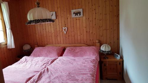 菲施Chalet Sonnenblick的一间卧室配有一张带红色和白色棉被的床