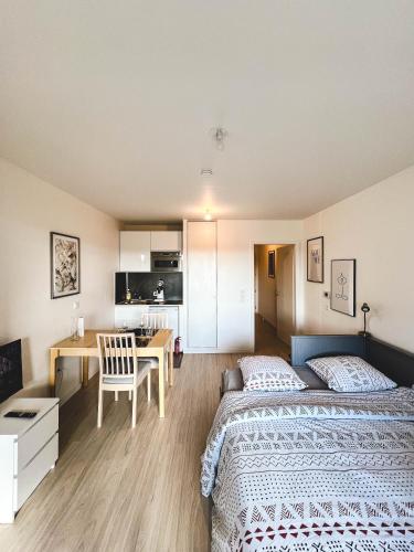 圣路易Studio Le Hésingue- Near Airport, Swiss & German board的一间带两张床和一张书桌的卧室以及一间厨房