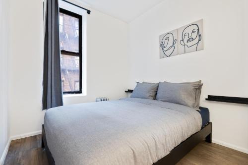 纽约Inspiring Urban Life, Times square Apartments的一间卧室设有一张床和一个窗口