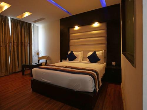 新德里Oyo Hotel Luxury Inn Near Dhaula Kuan Delhi的一间卧室,卧室内配有一张大床