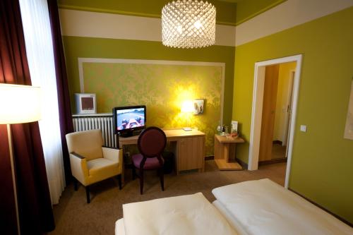 格罗瑙施普斯酒店的一间卧室配有一张床、一张桌子和一把椅子