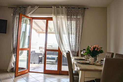菲乌米奇诺Giramondo Guest house的一间设有桌子和玻璃门的用餐室