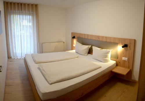 布尔足尔特劳伯宾馆的卧室配有一张带白色床单和枕头的大床。