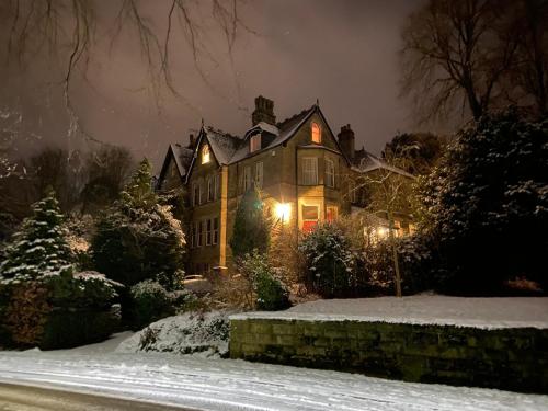 巴克斯顿Ashleigh Buxton的夜晚雪中灯火通明的房子