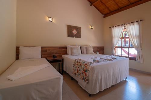 布罗塔斯Pousada Pé na Terra的一间卧室设有两张床和窗户。