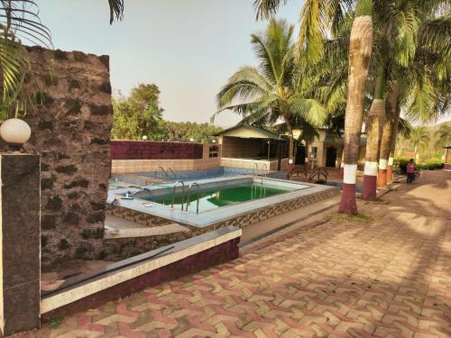VihurNargis Farm Resort的棕榈树庭院内的游泳池