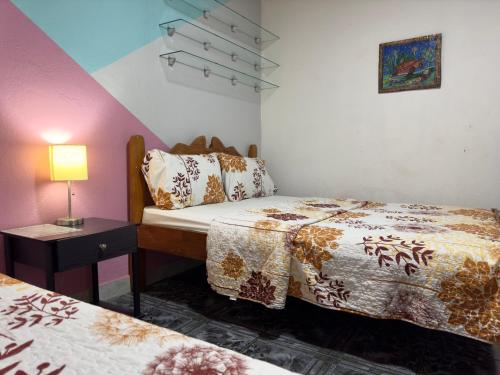 奎波斯城Casa Quepos的一间卧室配有两张床和一张带台灯的桌子