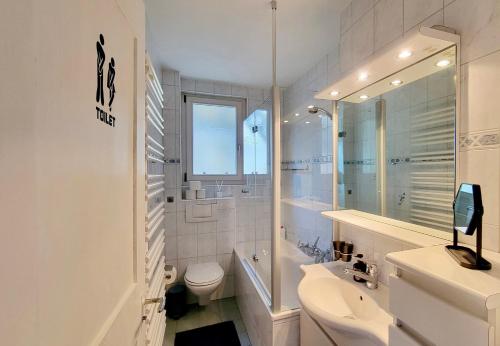 WimmisMountain Holiday的白色的浴室设有卫生间和水槽。