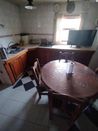 乌斯怀亚Ushuaia hospedaje的厨房配有木桌、椅子和水槽