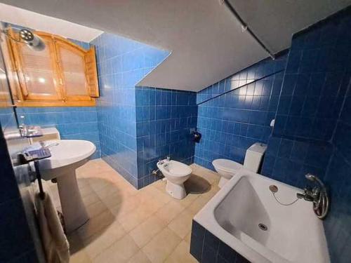 OsmaWAXSIMA Burgo de Osma的蓝色瓷砖浴室设有卫生间和水槽