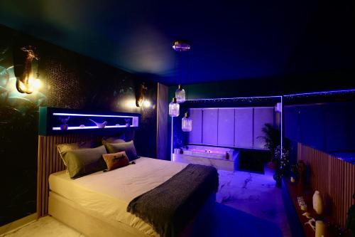 滨海拉塞讷Flower Suite and Spa的紫色客房内的一间卧室,配有一张床
